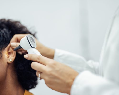 Ear examination, close-up. Doctor using medical instrument for ear examination.