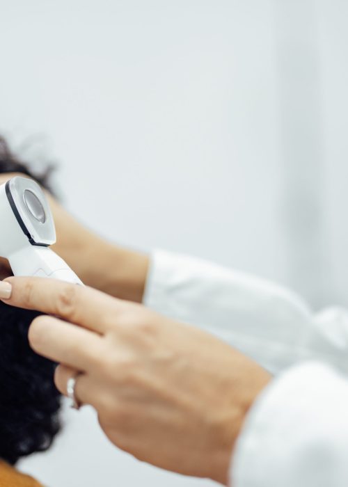 Ear examination, close-up. Doctor using medical instrument for ear examination.