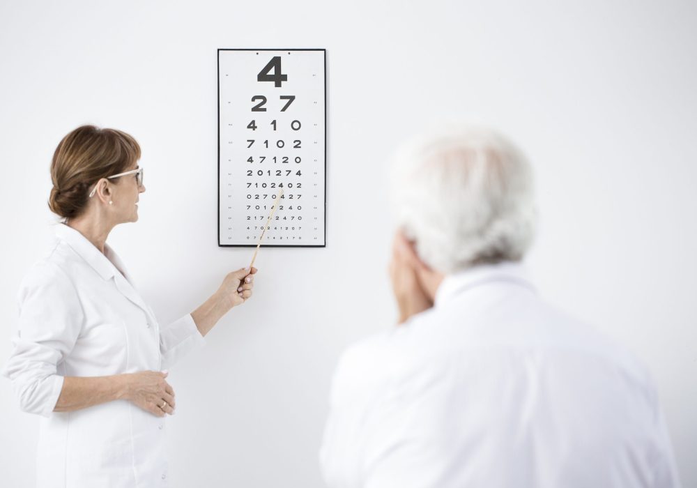 Ophthalmologist indicating letters on the board during examining a patient