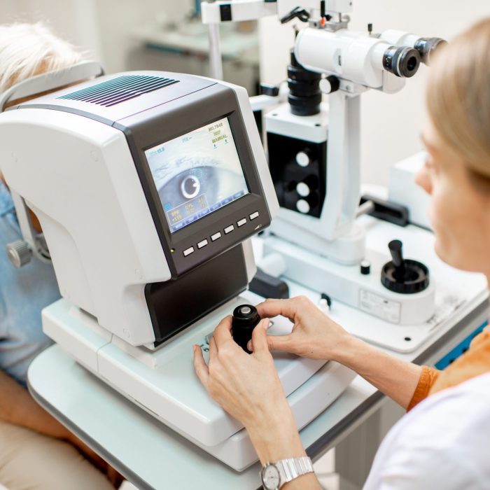 Ophthalmologist examining eyes of a senior patient using digital microscope during a medical examination in the ophthalmologic office